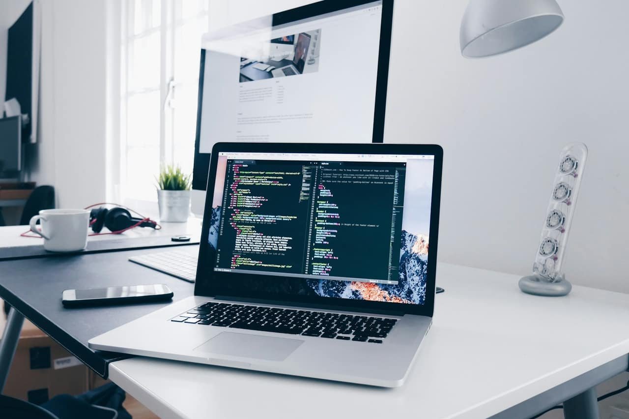 Bureau de création : laptop, second écran et code à l’écran